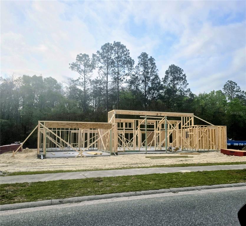A wooden frame of a house under construction sits on a concrete slab foundation — 247 SW BELLFLOWER DRIVE, LAKE CITY, FL
