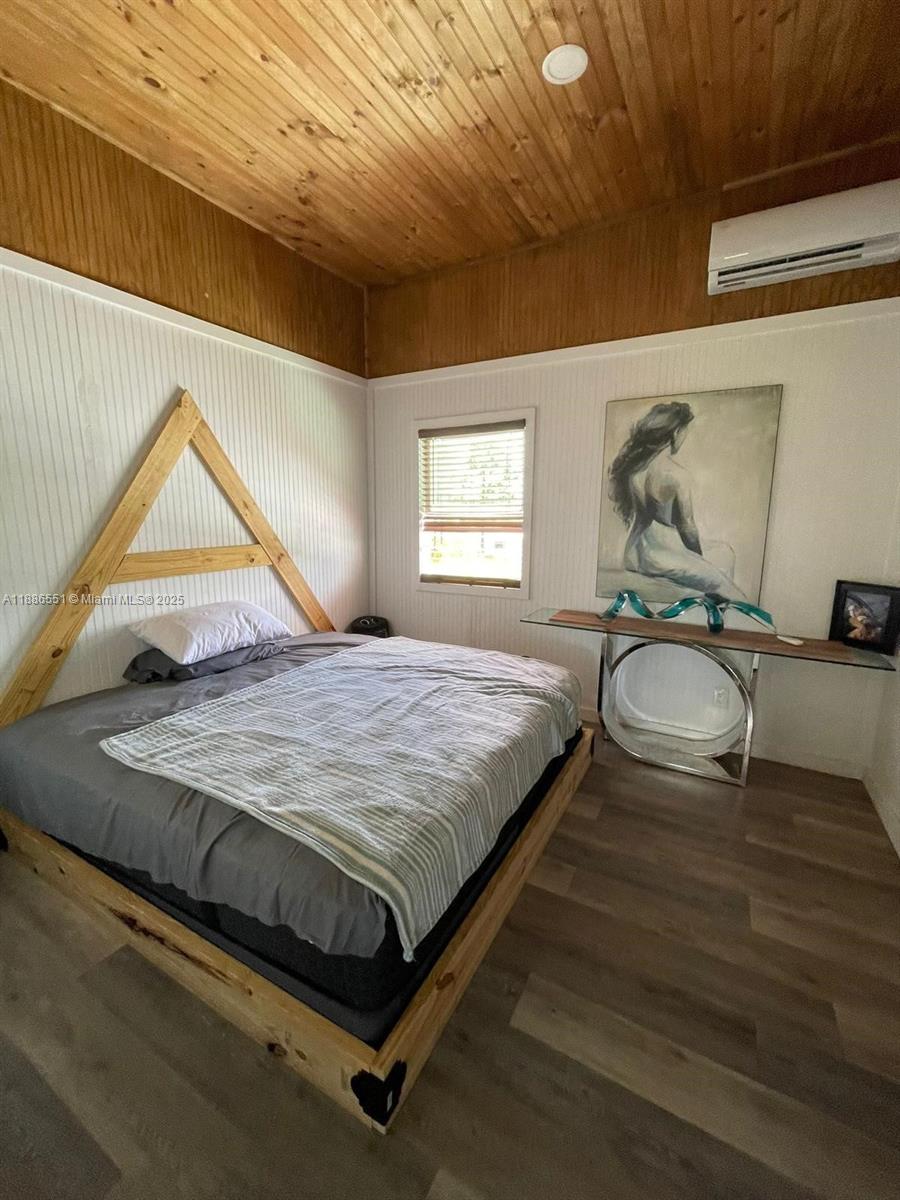 A bedroom features a wooden A-frame headboard, wood-paneled ceiling, and a glass-topped console table — 0 Highway 630 E, Frostproof FL 33843, FROSTPROOF, FL