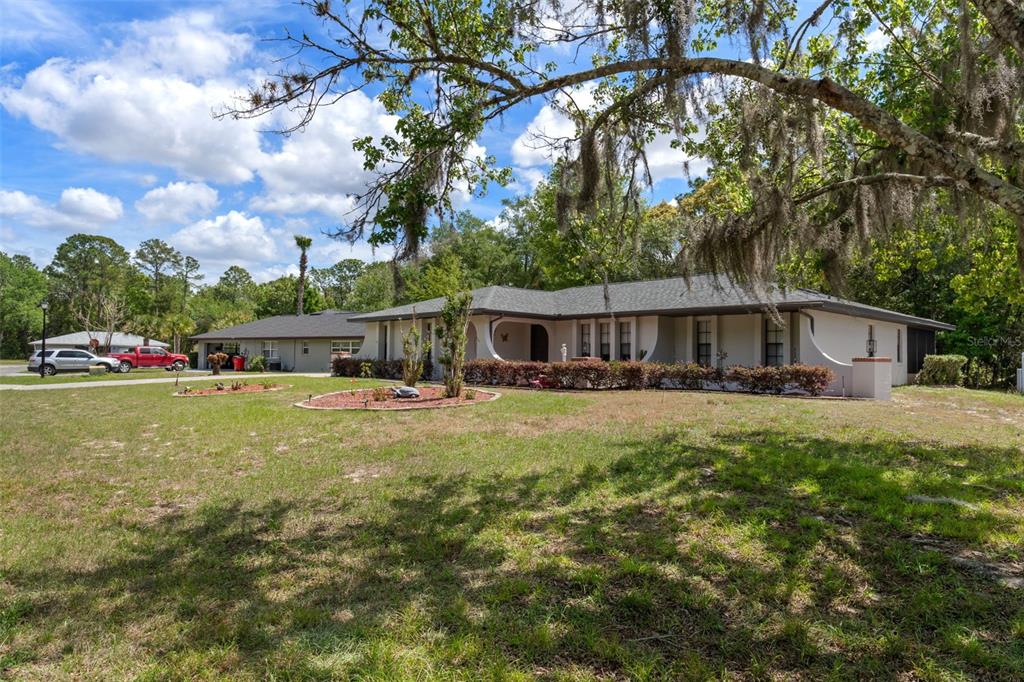 A single-story house with a gray roof and light-colored exterior sits on a grassy lot — 5 MANGROVE COURT S, HOMOSASSA, FL