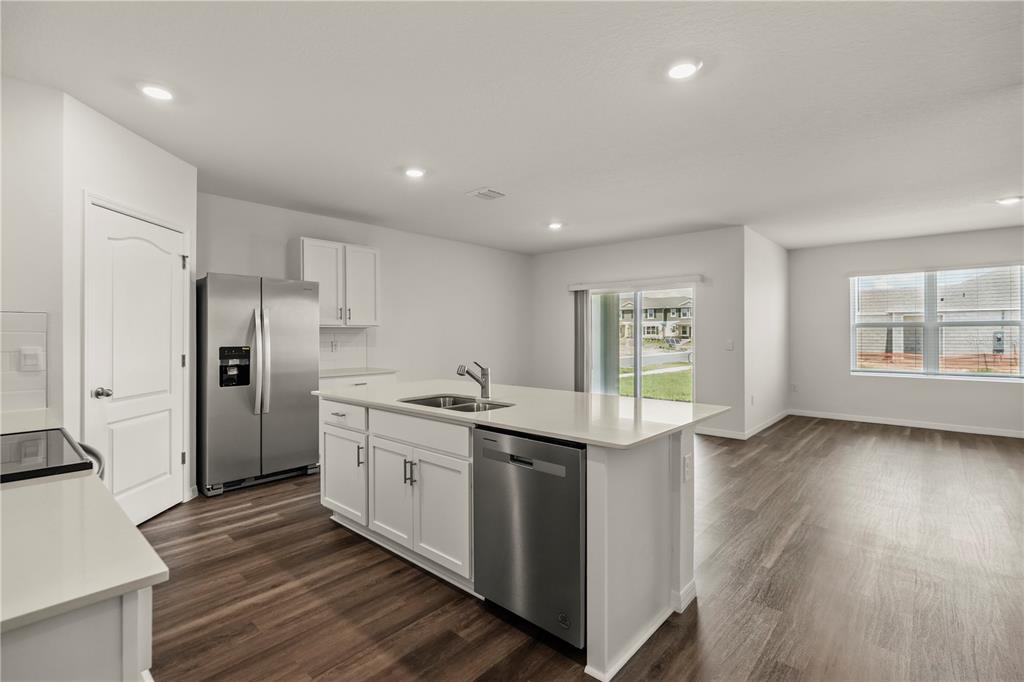A kitchen with white cabinets, stainless steel appliances, and an island with a sink — 1699 THREE BARS ROAD, KISSIMMEE, FL