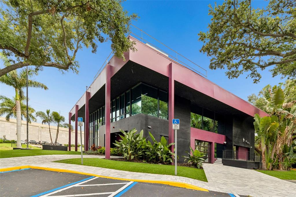 A modern two-story commercial building with dark walls, maroon accents, and surrounding landscaping — 19995 US HIGHWAY 19 N, CLEARWATER, FL