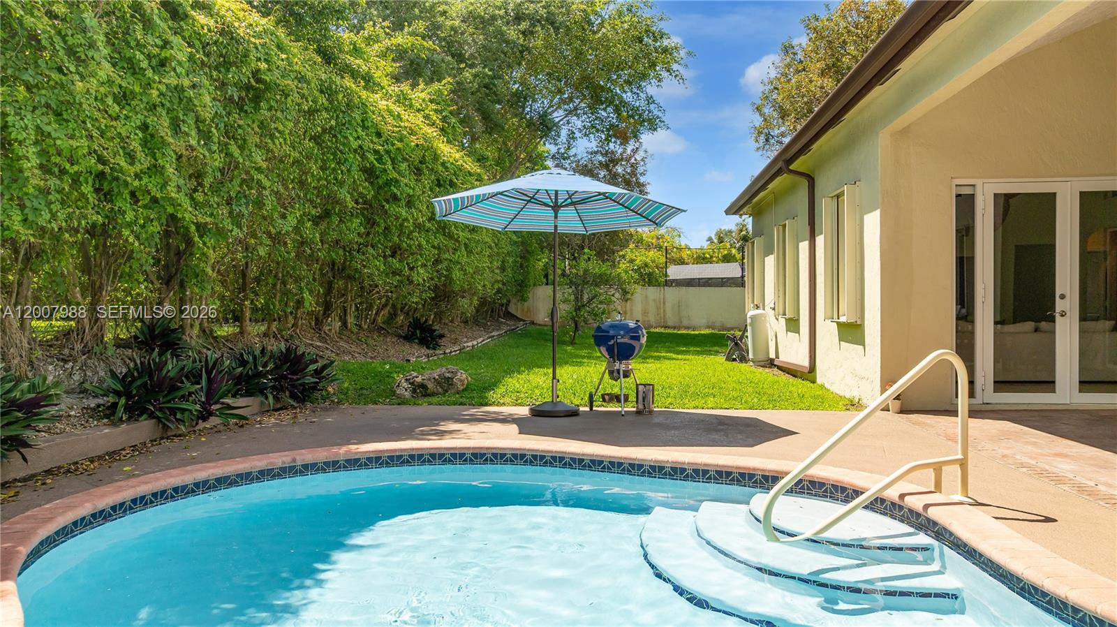 A backyard features a swimming pool with steps, a patio, a grill, and an umbrella — 14831 SW 95th Ct, Miami FL 33176, MIAMI, FL