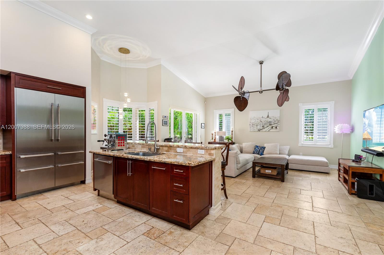 A kitchen with dark wood cabinets and granite countertops opens into a living area — 14831 SW 95th Ct, Miami FL 33176, MIAMI, FL