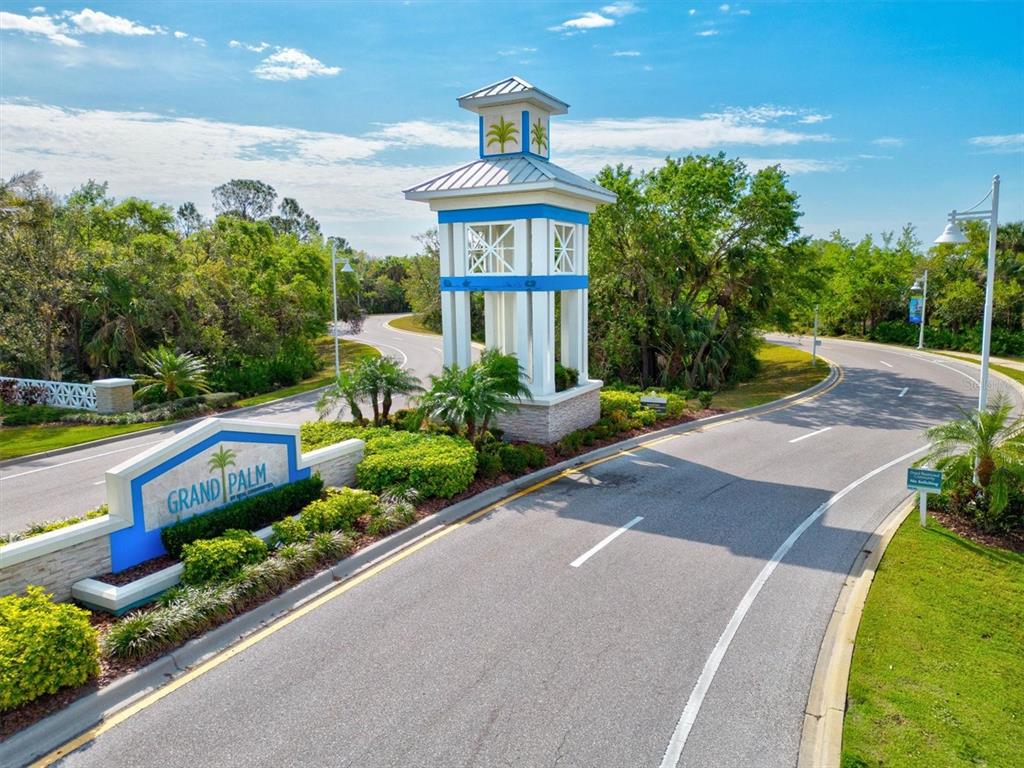 The entrance to the Grand Palm community features a tall decorative tower and signage — 11876 HUNTERS CREEK ROAD, VENICE, FL