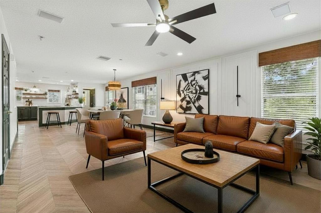 A living room features a leather sofa and armchair, a coffee table, and wood flooring — 504 WHEATON TRENT PLACE, TAMPA, FL
