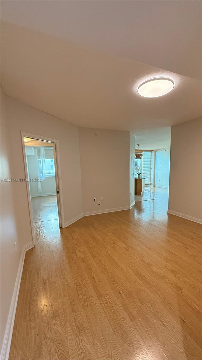 An interior view shows a room with light wood flooring, a doorway, and a ceiling light — 1745 E Hallandale Beach Blvd # 306W, Hallandale Beach FL 33009, HALLANDALE BEACH, FL