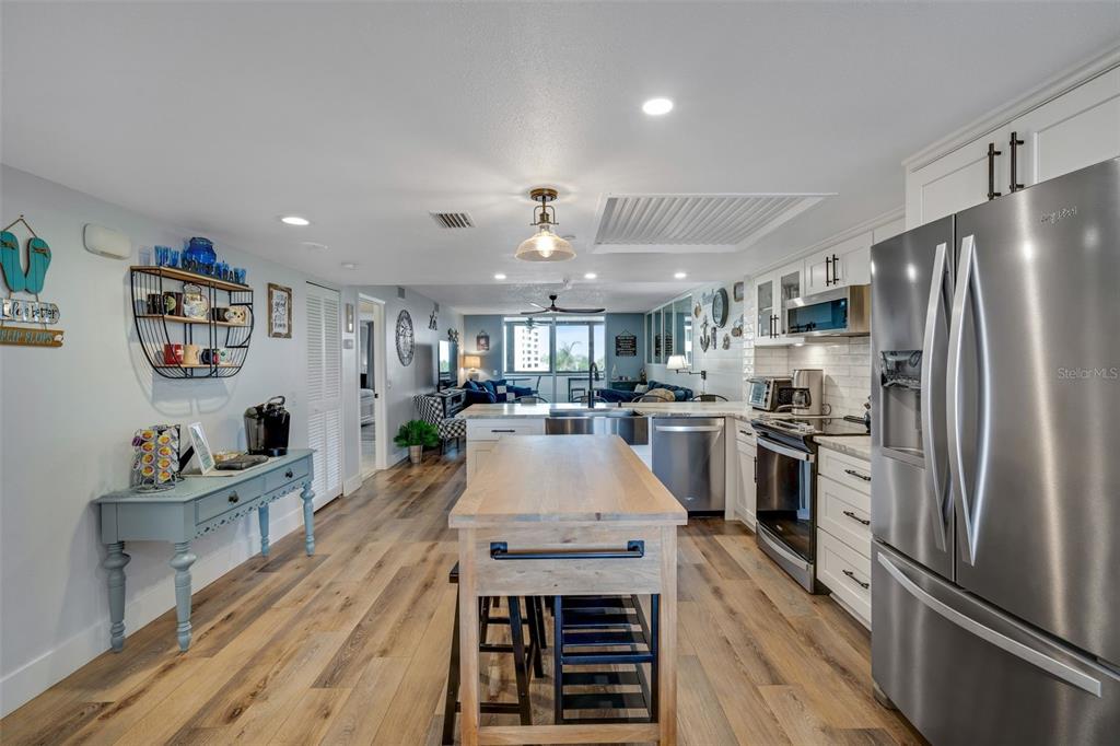 A kitchen with a wood-topped island, stainless steel appliances, and light wood-look flooring — 6035 SEA RANCH DRIVE UNIT 215, HUDSON, FL