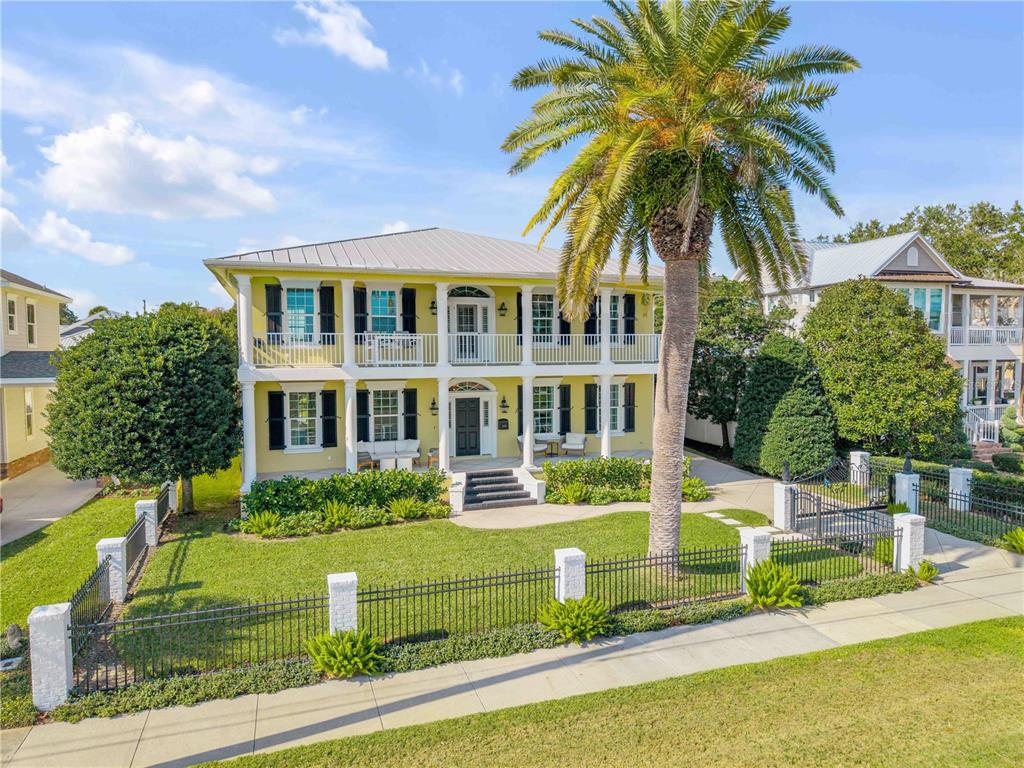 A two-story yellow house with a metal roof, front porches, and a palm tree — 1212 S RIVERSIDE DRIVE, NEW SMYRNA BEACH, FL