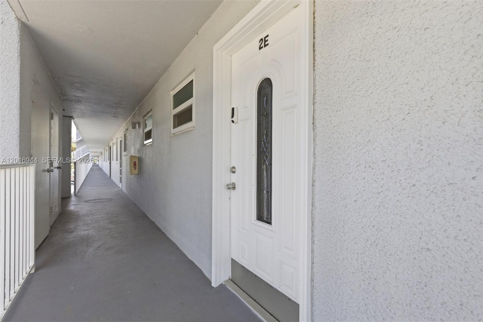 An exterior hallway shows a white door labeled 2E with a decorative glass insert — 111 Royal Park Dr # 2E, Oakland Park FL 33309, OAKLAND PARK, FL