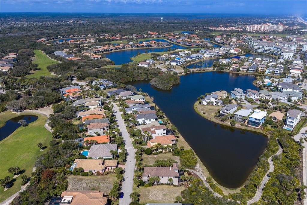 An aerial view shows a residential neighborhood with houses surrounding a large lake — 29 SANDPIPER LANE, PALM COAST, FL