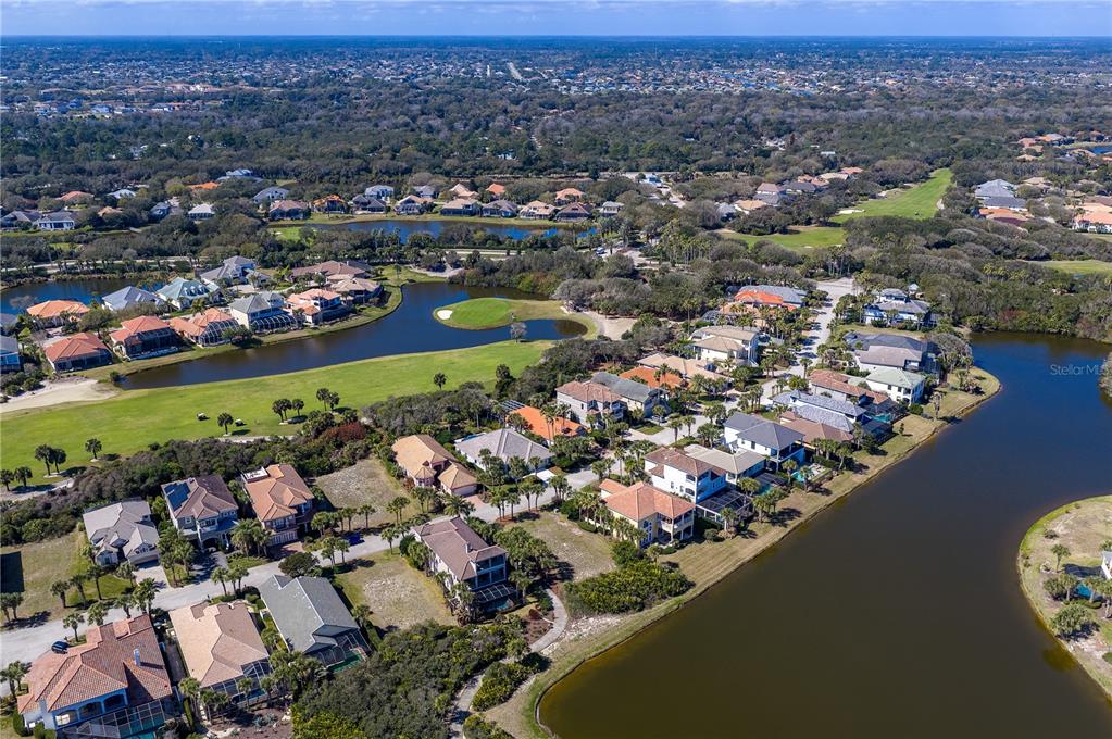An aerial view shows a residential neighborhood with houses situated around a golf course lake — 29 SANDPIPER LANE, PALM COAST, FL