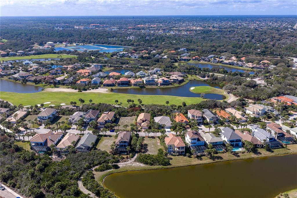 An aerial view shows a residential neighborhood with houses surrounding a golf course and ponds — 29 SANDPIPER LANE, PALM COAST, FL