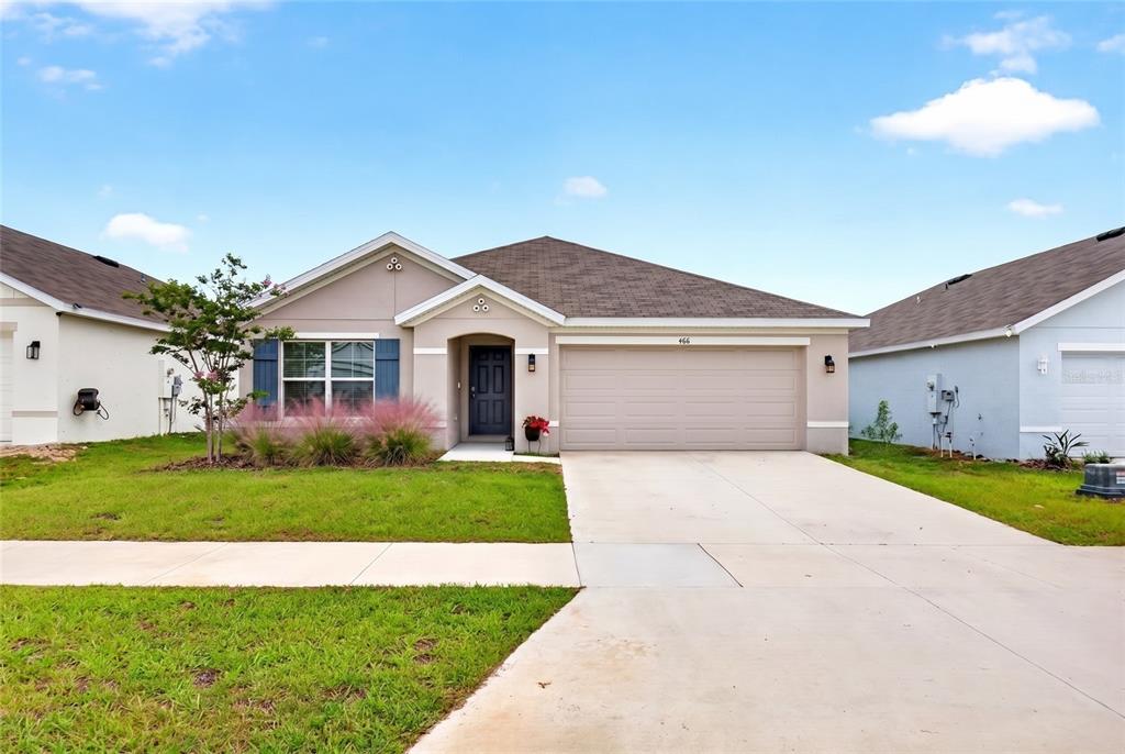 A single-story suburban house with a beige exterior, a two-car garage, and a front lawn — 4716 SW 85TH PLACE, OCALA, FL