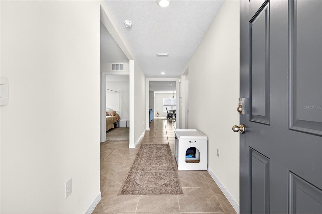 A tiled entryway leads into a hallway with a bedroom and a dining area visible — 4716 SW 85TH PLACE, OCALA, FL