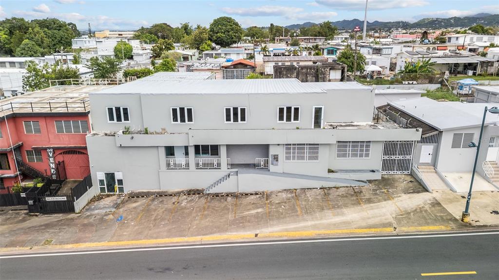 An aerial view of a two-story gray commercial building with a parking lot in front — 3RD STREET HERNAOS DAVILA, BAYAMON, PR