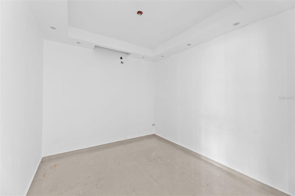 An empty room with white walls, a tray ceiling with recessed lighting, and tiled flooring — 3RD STREET HERNAOS DAVILA, BAYAMON, PR