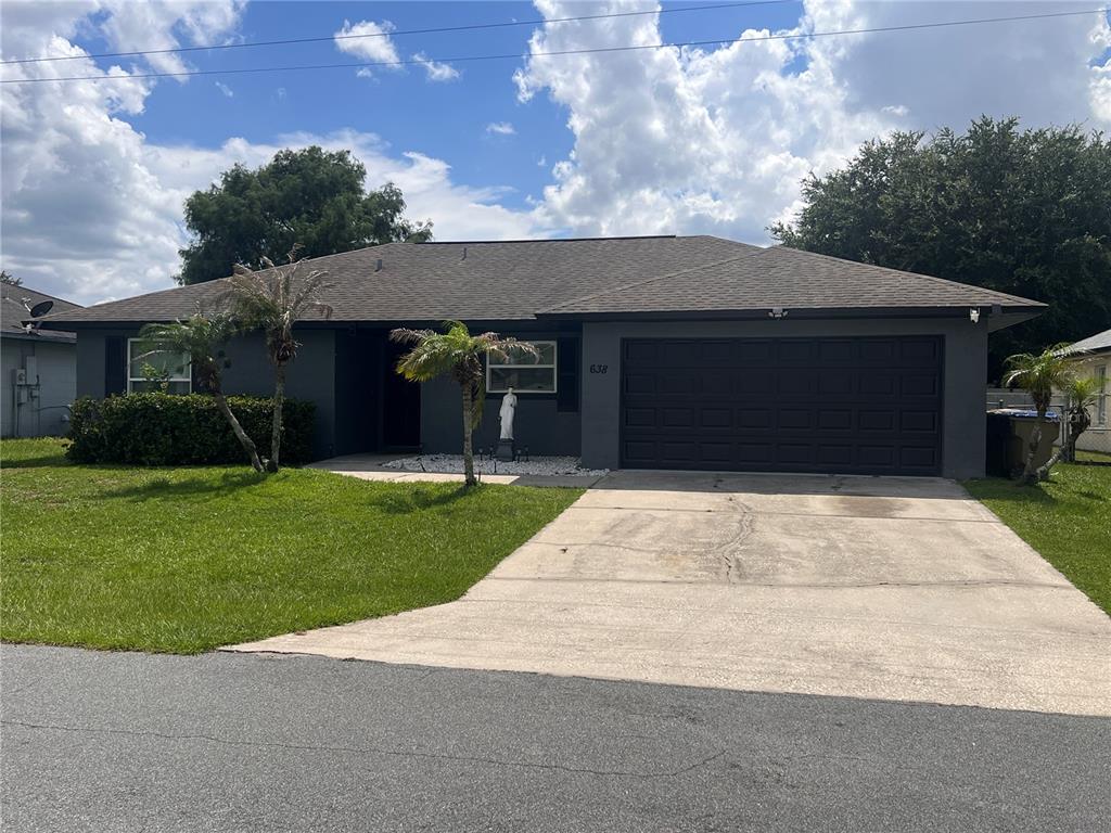 An open-concept living and dining area features tile flooring, a large television, and sliding doors — 638 BALDWIN DRIVE, KISSIMMEE, FL