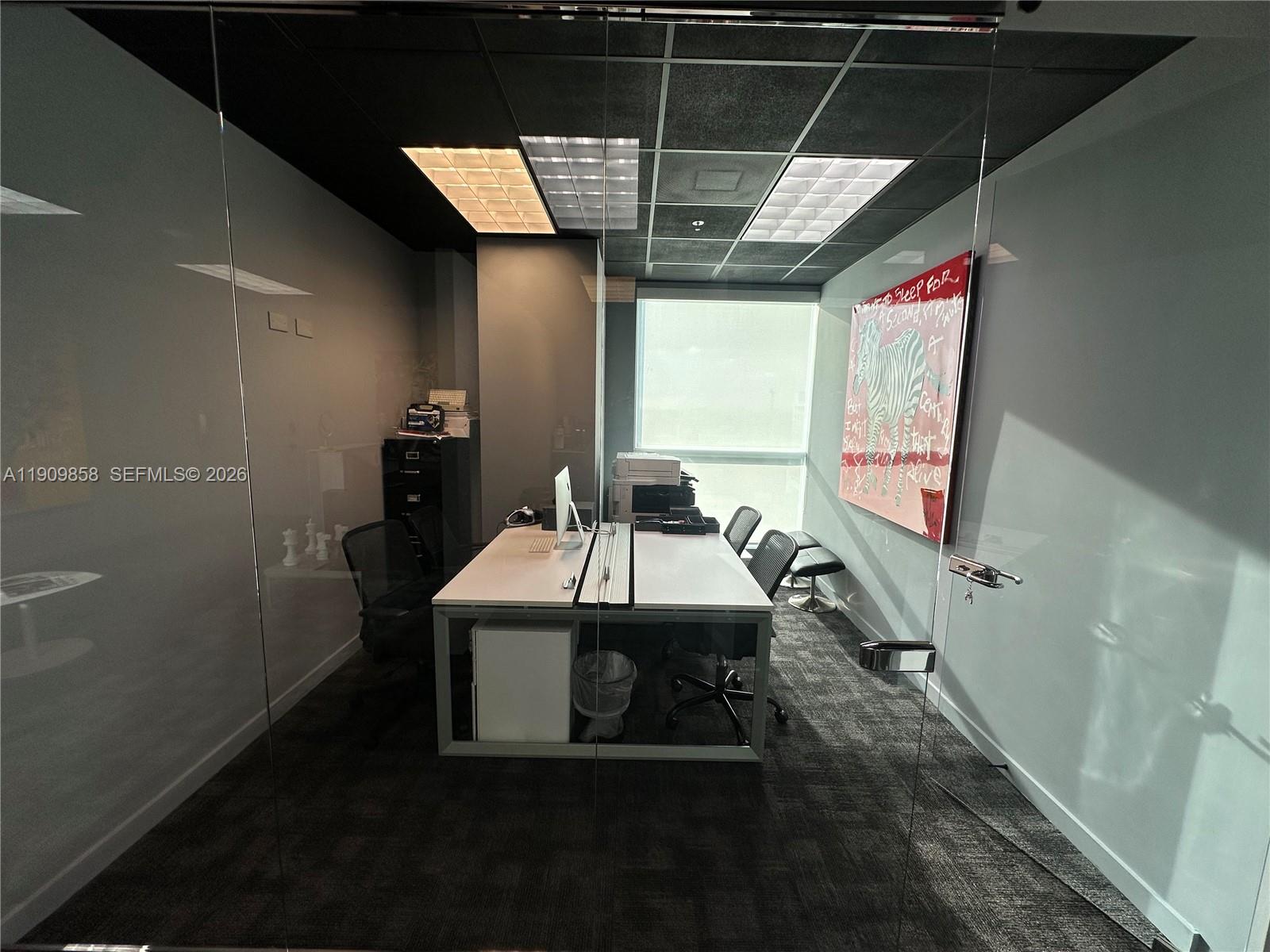 A modern office features a glass-walled entrance, a double desk, and a large zebra painting — 175 SW 7 ST # 1101, Miami FL 33130, MIAMI, FL