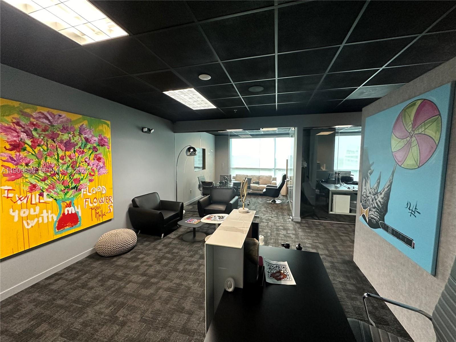 A modern office space features dark carpet, a black drop ceiling, and two large paintings — 175 SW 7 ST # 1101, Miami FL 33130, MIAMI, FL