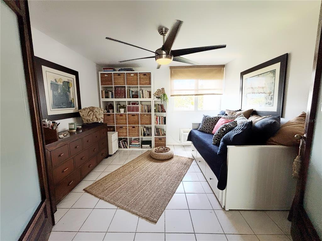 A bedroom with white tile floors, a daybed, a dresser, and a large shelving unit — PH 1-A ARROYO BEACH RESORT UNIT PH1-A, ARROYO, PR