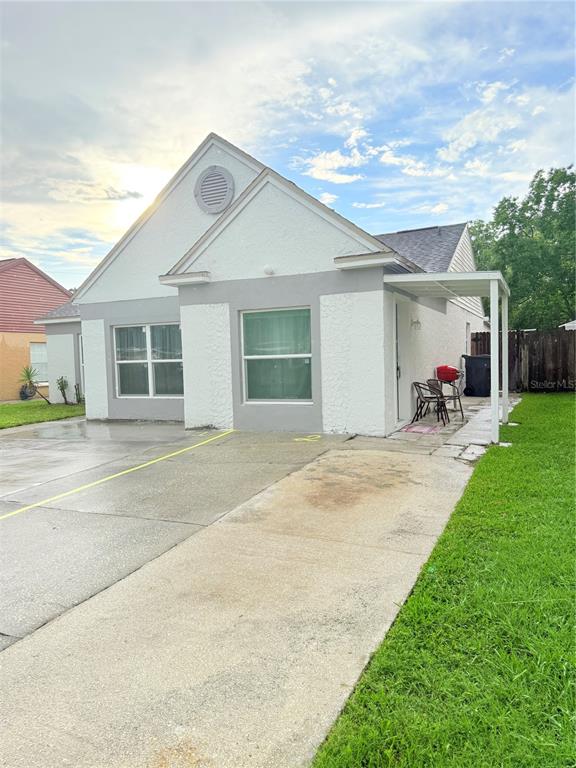 A single-story duplex with a concrete driveway, white stucco exterior, and a small covered patio — 2130 REDLEAF DRIVE, BRANDON, FL