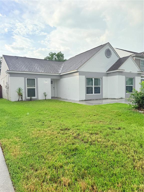 A single-story house with white stucco walls, gray trim, and a dark shingled roof — 2130 REDLEAF DRIVE, BRANDON, FL