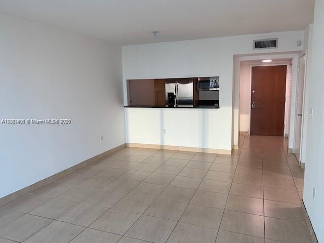 An interior view shows a tiled living area with a kitchen pass-through window — 31 SE 5th St # 2603, Miami FL 33131, MIAMI, FL