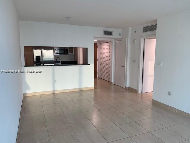 An interior view shows a tiled living area with a kitchen pass-through window — 31 SE 5th St # 2603, Miami FL 33131, MIAMI, FL
