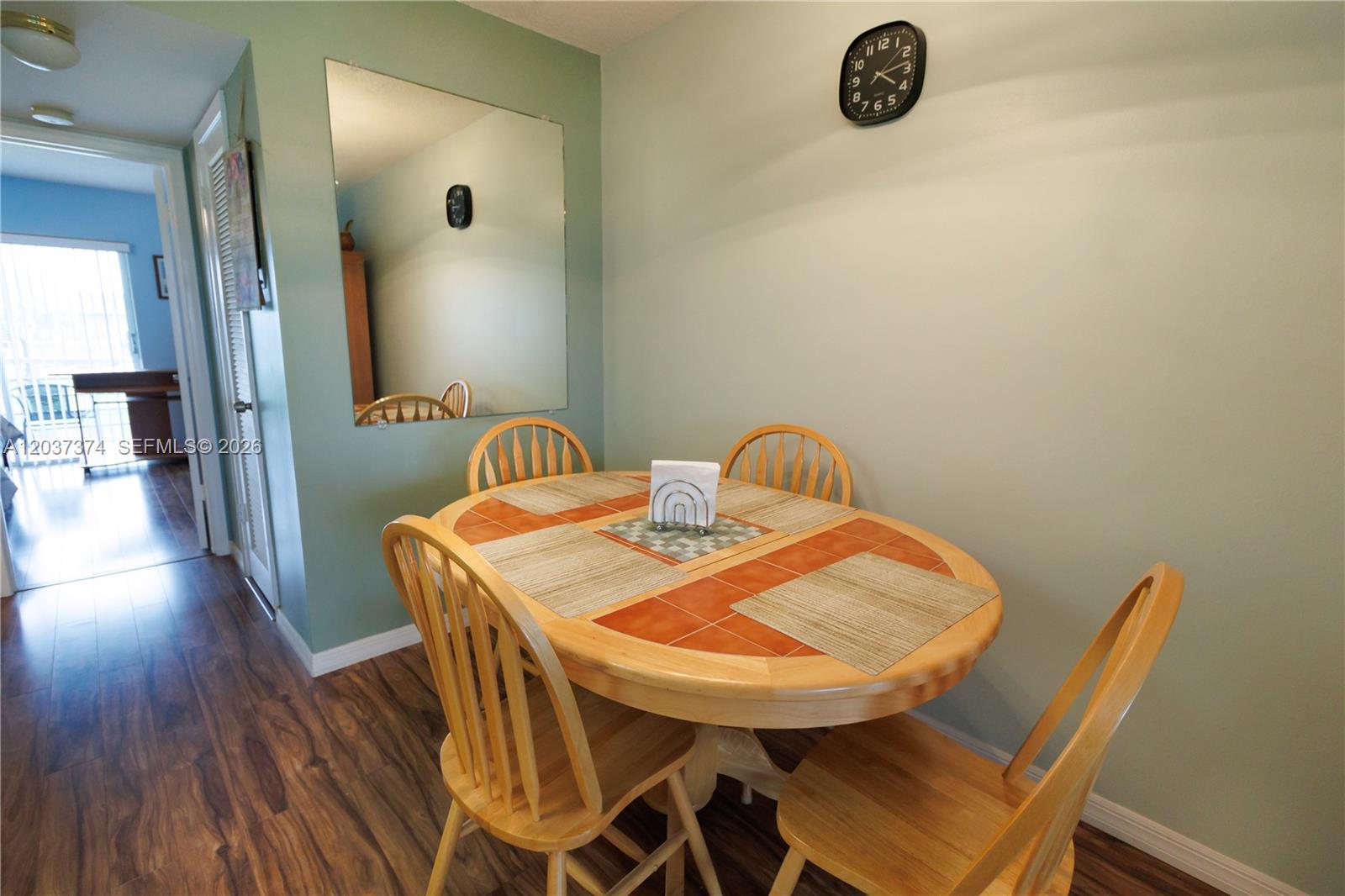 A dining area features a wooden table with tiled insets, four chairs, and a wall mirror — 90 Berkshire D # 90, West Palm Beach FL 33417, WEST PALM BEACH, FL
