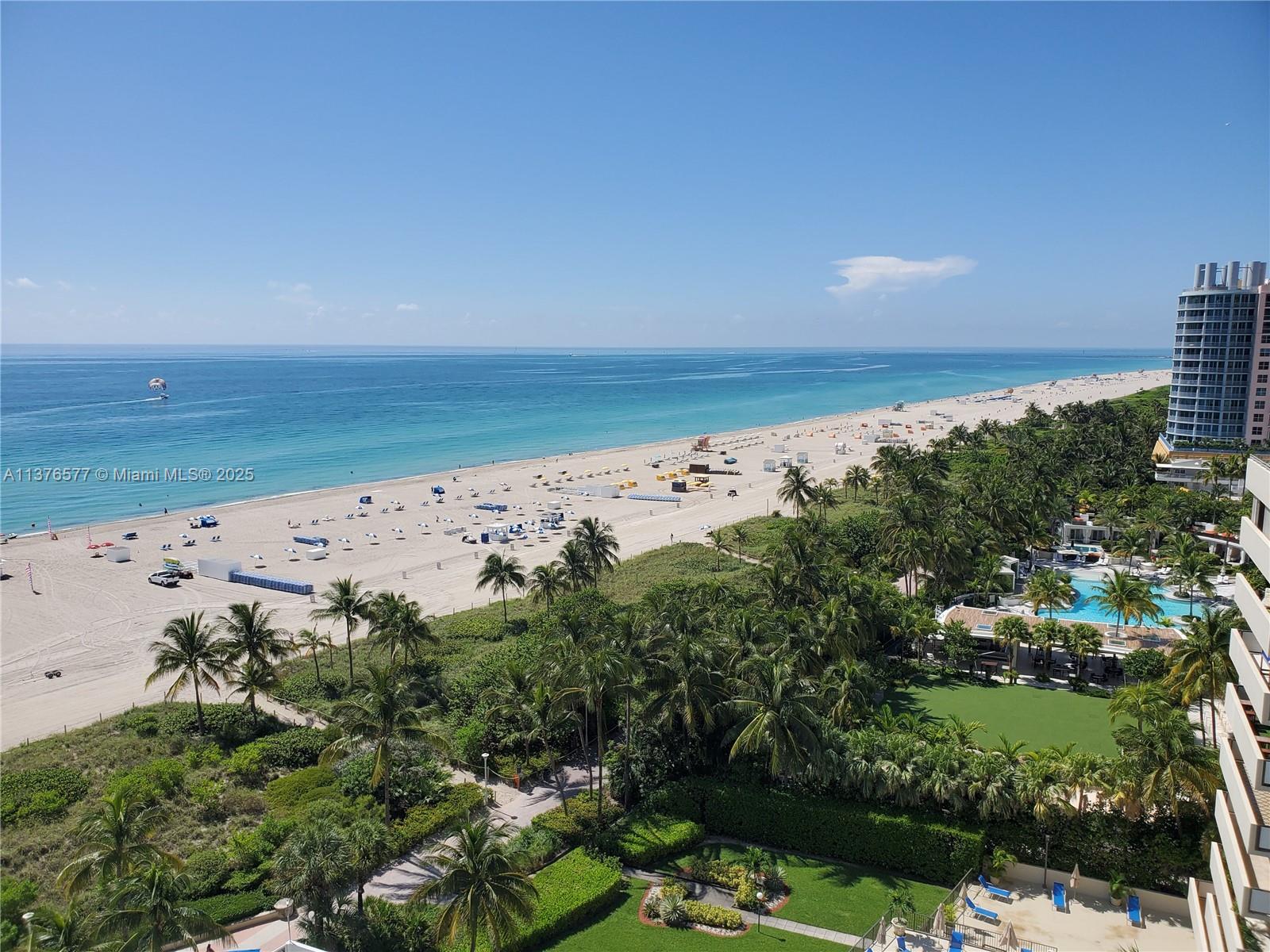 An elevated view of a sandy beach, palm trees, and a high-rise building — 100 Lincoln Rd # 1244, Miami Beach FL 33139, MIAMI BEACH, FL