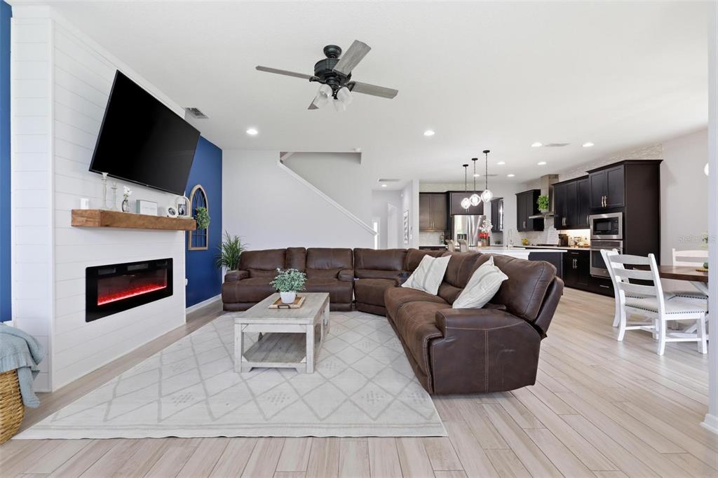 A living room features a fireplace, a large brown sectional, and an open-concept kitchen — 297 ANCONA AVENUE, DEBARY, FL