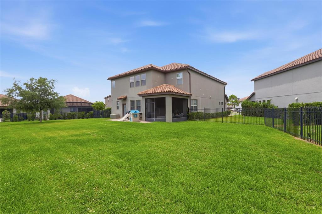 A two-story house with a screened-in patio sits on a large, fenced-in grassy lawn — 297 ANCONA AVENUE, DEBARY, FL
