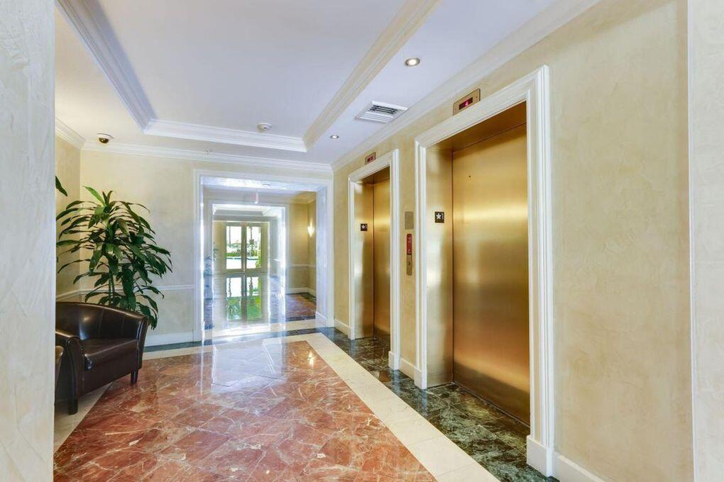 A hallway features a red marble floor, two gold elevator doors, and a potted plant — 806 E Windward Way # 401, Lantana FL 33462, LANTANA, FL