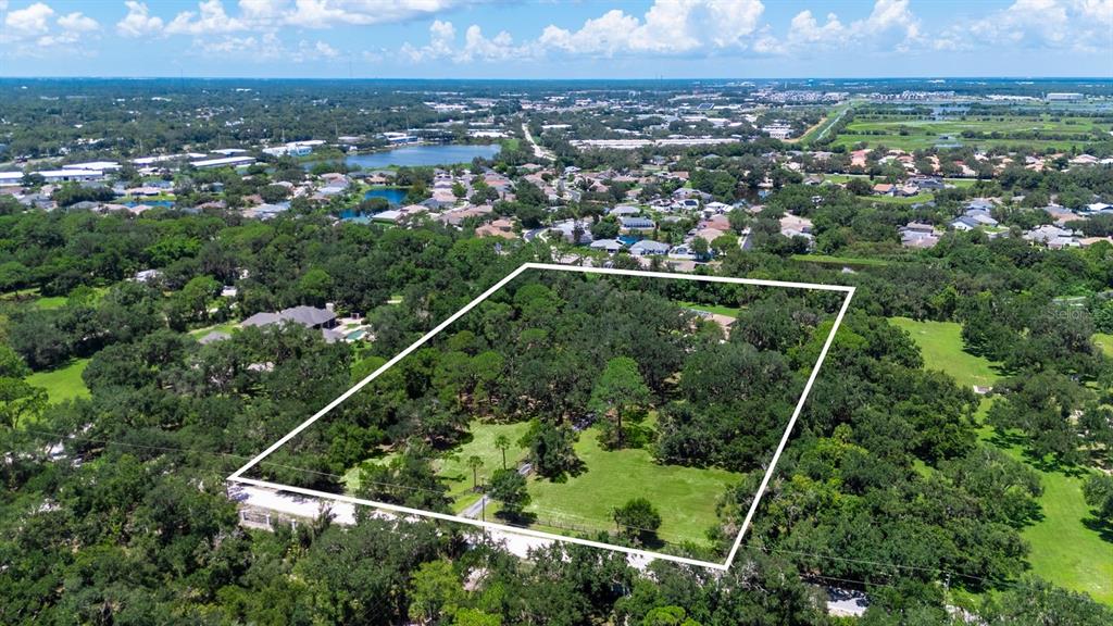 An aerial view shows a large, wooded residential lot outlined in white — 6455 MCKOWN ROAD, SARASOTA, FL