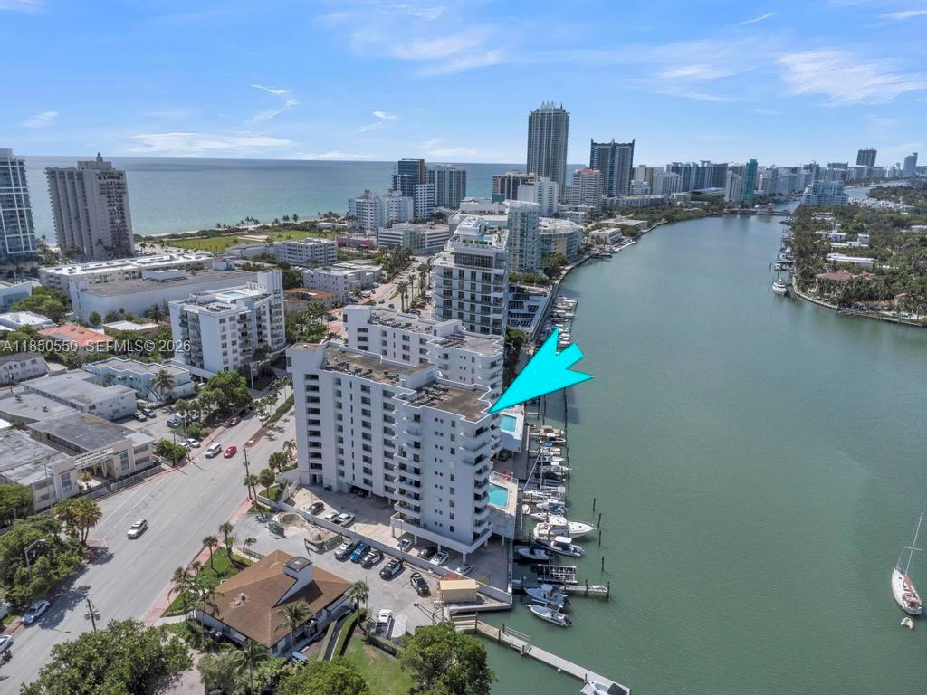 A balcony overlooks a swimming pool, a marina with boats, and a bay — 6830 Indian Creek Dr # 6D, Miami Beach FL 33141, MIAMI BEACH, FL