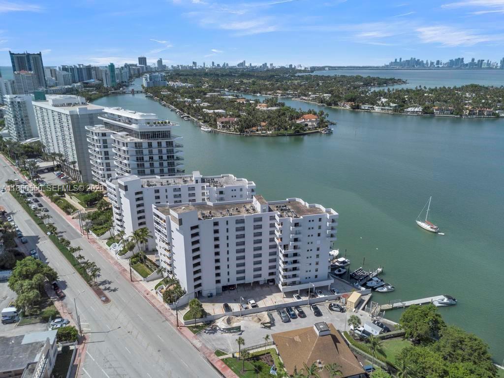 A virtually staged bedroom features a bed, two chairs, and a balcony with outdoor views — 6830 Indian Creek Dr # 6D, Miami Beach FL 33141, MIAMI BEACH, FL