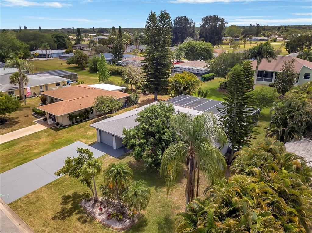 An aerial view of a suburban neighborhood featuring houses with screened lanais and palm trees — 60 GOLFVIEW ROAD, ROTONDA WEST, FL