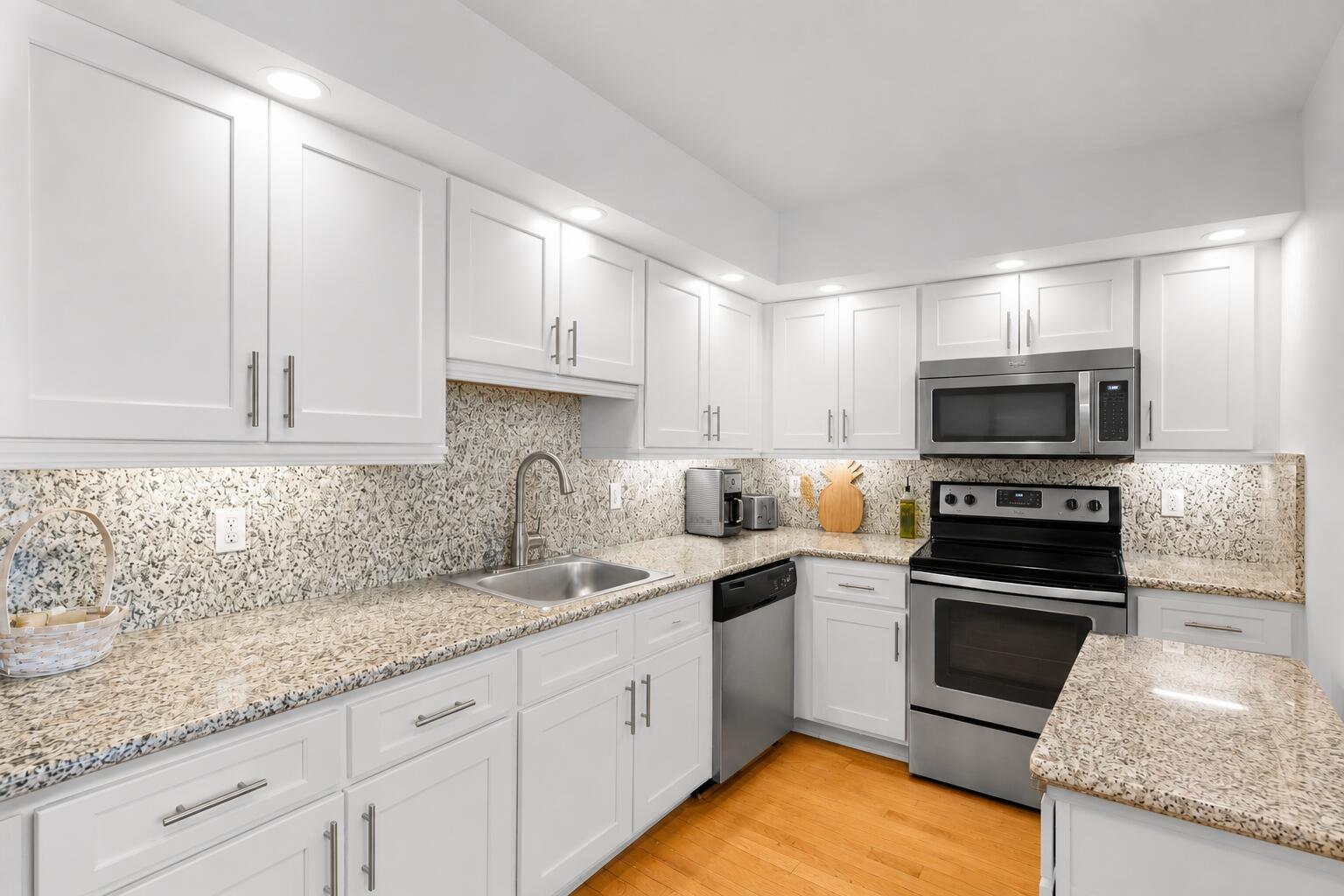 A kitchen with white cabinets, granite countertops, stainless steel appliances, and a patterned backsplash — 625 Oaks Drive # 405, Pompano Beach FL 33069, POMPANO BEACH, FL