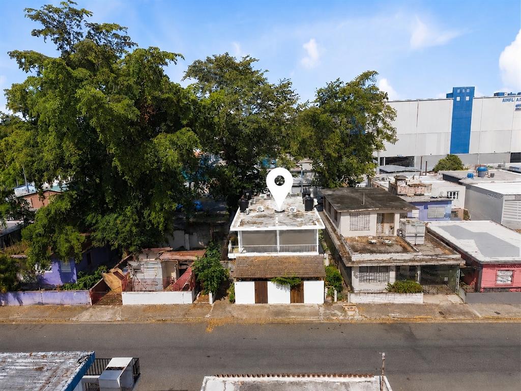 An aerial view shows a two-story house with a white facade and a flat roof — 211 CALLE TAPIA, SAN JUAN, PR