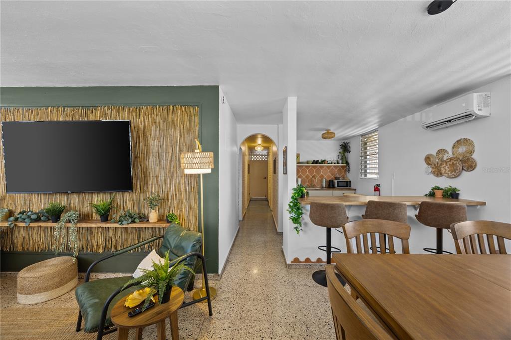 A living room with a bamboo accent wall, a hallway, and a kitchen breakfast bar — 211 CALLE TAPIA, SAN JUAN, PR