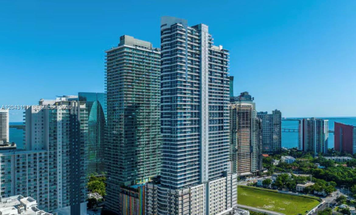 An aerial view of several modern high-rise residential buildings in an urban waterfront setting — 60 SW 13th St # 1416, Miami FL 33130, MIAMI, FL
