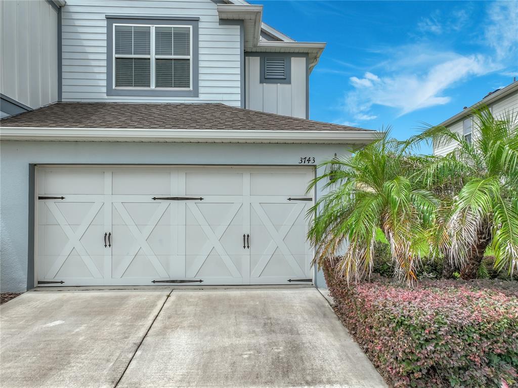 A two-story house exterior features a white carriage-style garage door and a small palm tree — 3743 PLAINVIEW DRIVE, ORLANDO, FL