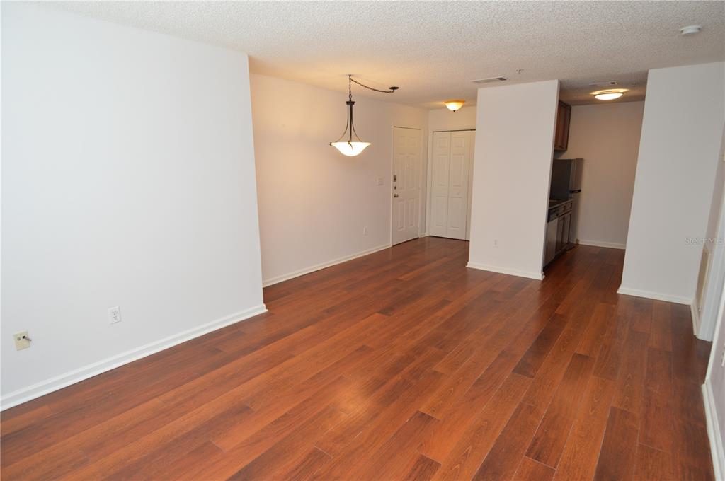 An interior view of an open-concept living and dining area with wood-look flooring — 11901 4TH STREET N UNIT 7204, ST PETERSBURG, FL