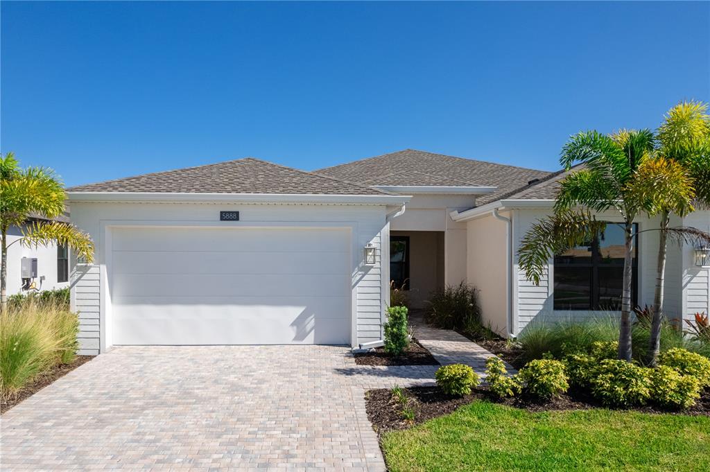A single-story house with a white exterior, a two-car garage, and a paved driveway — 5888 WINDBREAK COURT, APOLLO BEACH, FL