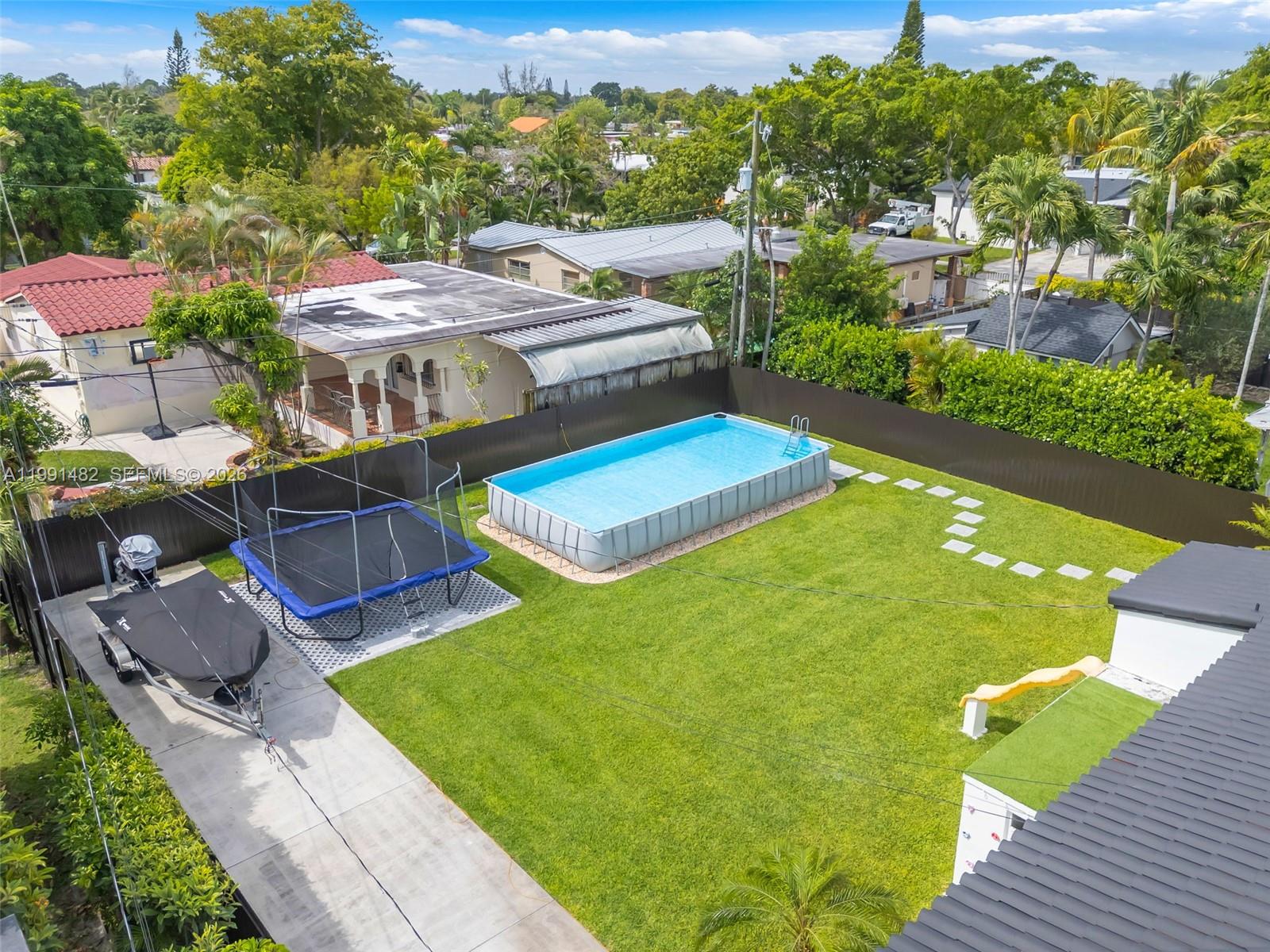 An aerial view shows a backyard with a rectangular above-ground pool, trampoline, and boat trailer — 7940 SW 20th Street, Miami FL 33155, MIAMI, FL