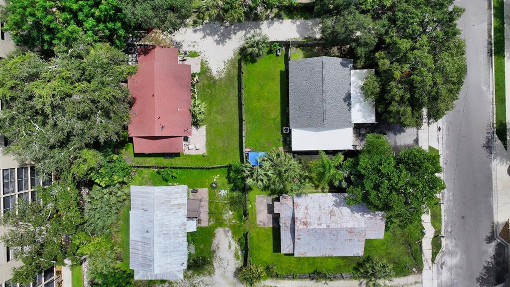 An aerial view shows four residential houses surrounded by trees and green lawns — 1555 7TH STREET, SARASOTA, FL