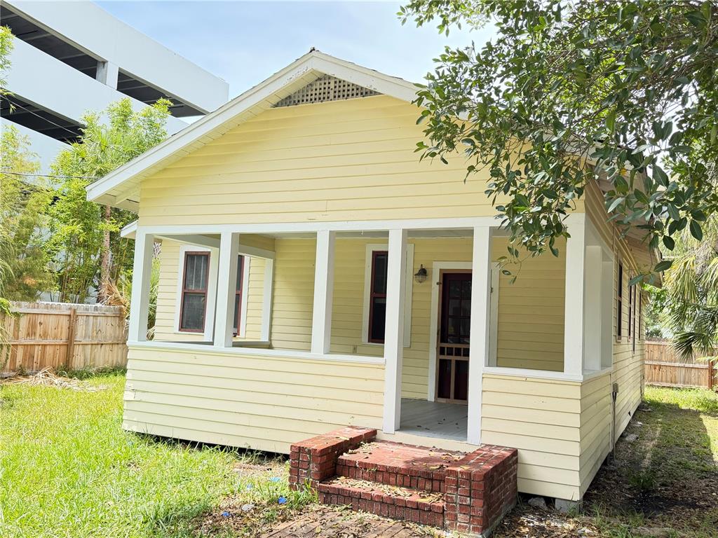 A yellow, single-story house with a screened-in front porch and brick steps — 1555 7TH STREET, SARASOTA, FL