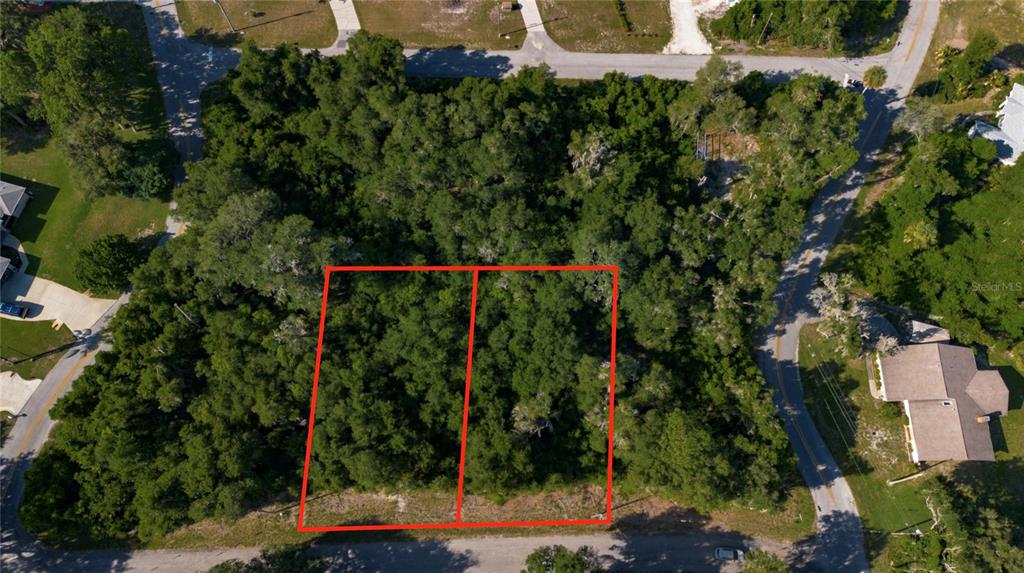 An aerial view shows two adjacent, wooded, undeveloped rectangular lots outlined in red — 4362 E MATE LANE, HERNANDO, FL