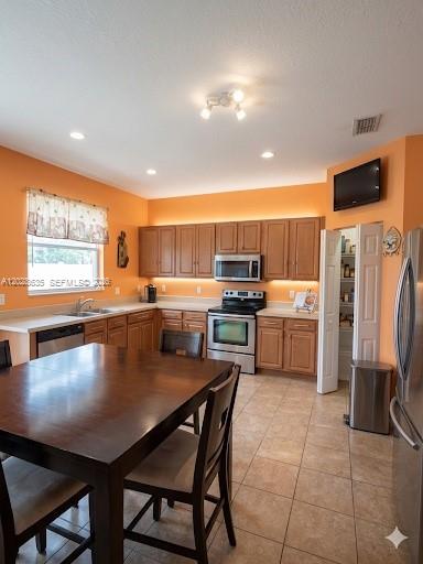 A kitchen with wood cabinets, stainless steel appliances, and a dining table in the foreground — 342 STAR SHELL DR, Tampa FL 33572, TAMPA, FL