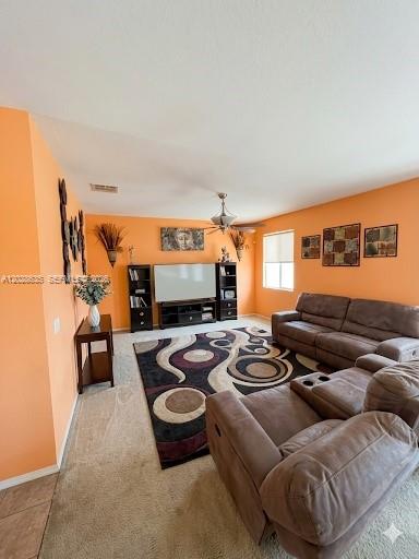 A living room features orange walls, a large patterned area rug, and brown leather furniture — 342 STAR SHELL DR, Tampa FL 33572, TAMPA, FL